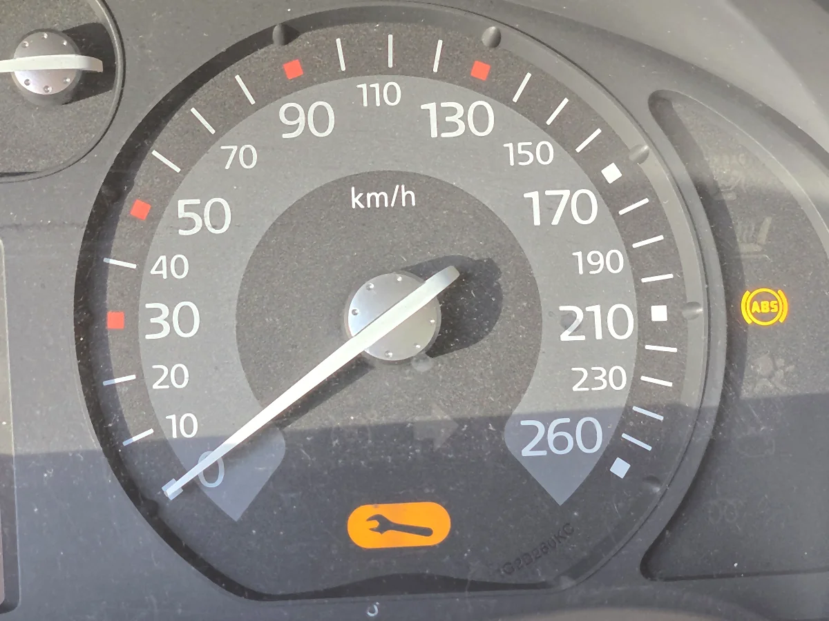 Zegary Renault Laguna II na postoju, prędkościomierz na 0 km/h ze skalą do 260, świecąca żółta kontrolka ABS i pomarańczowa kontrolka klucza serwisowego
