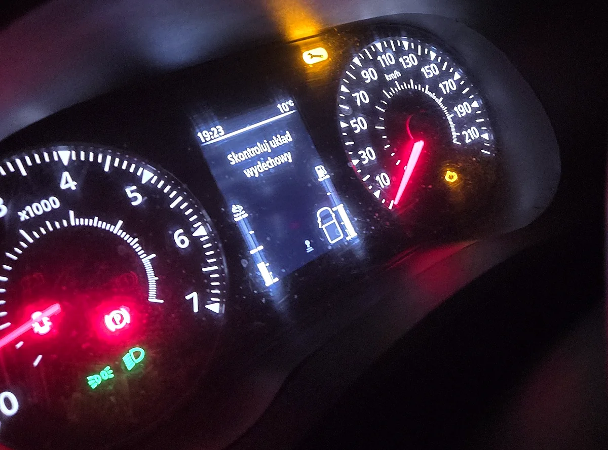 Zestaw wskaźników Renault Master III nocą z komunikatem Skontroluj układ wydechowy na wyświetlaczu, świecącą pomarańczową kontrolką serwisową w kształcie klucza i kontrolką silnika, temperatura zewnętrzna 10 stopni